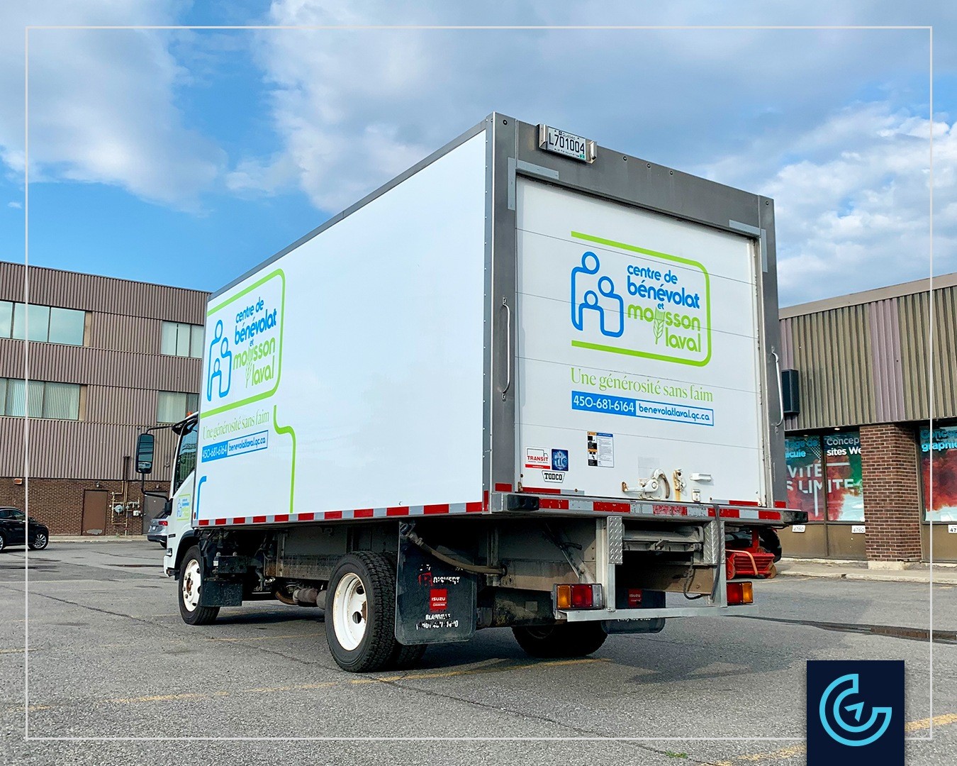 Lettrage de camion sur un camion Isuzu avec une boîte cargo de 16 pieds pour Centre de Bénévolat et Moisson Laval.