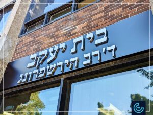 Building storefront signs in stainless steel canned letters on aluminium faces manufactured and installed for Beth Jacob seminary.
