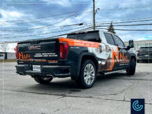 Pickup truck partial wrap and lettering on a 2022 GMC Sierra Crew Cab Standard Bed for the construction company NAEL Construction.