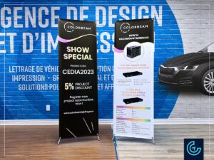 Bannières promotionnelles et supports de bannières en forme de X imprimés pour un salon professionnel du fournisseur de solutions d'éclairage haut de gamme Colorbeam.