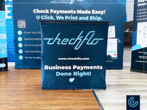Trade show booth including a pop-up backwall, a counter in dye-sublimated fabric and 2 roll-up banner stands for the payment technologie company Checkflo.