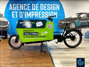 Promotional cargo bike wrap designed, printed and installed on a bike Riese & Transporter by Dumoulin Bicyclettes for a tool renting service Outil-O-Thèque by Ville en Vert.