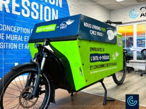Promotional cargo bike wrap designed, printed and installed on a bike Riese & Transporter by Dumoulin Bicyclettes for a tool renting service Outil-O-Thèque by Ville en Vert.