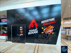 Impression et installation d'habillage de palissade de construction pour la nouvelle succursale de la franchise de restaurant Poulet Rouge situé dans la centre commerciale Place Rosemère.