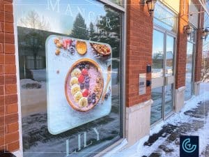 Graphiques de vitrine temporaires « Ouverture bientôt » conçus, imprimés et installés pour bar-café santé Lily, succursale à Ville Saint-Laurent.