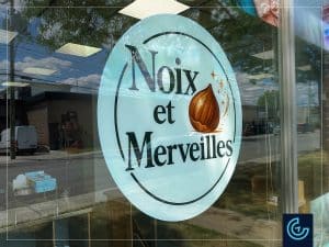 Impression et installation des graphiques de vitrine publicitaires pour le magasin de noix et de paniers cadeaux Noix et Merveilles.