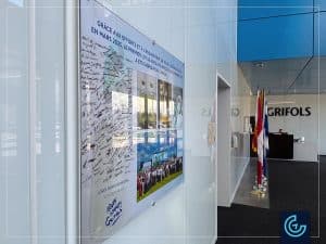 Conception, impression et installation d'un affichage des réalisations importantes avec de supports personnalisés pour le groupe pharmaceutique international Grifols à Montréal.
