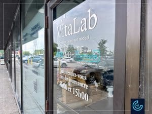 Storefront window graphics composed of frosted vinyl for privacy and die-cut color decals designed and installed for the new branch of medical laboratory Vitalab in Dollard-des-Ormeaux.