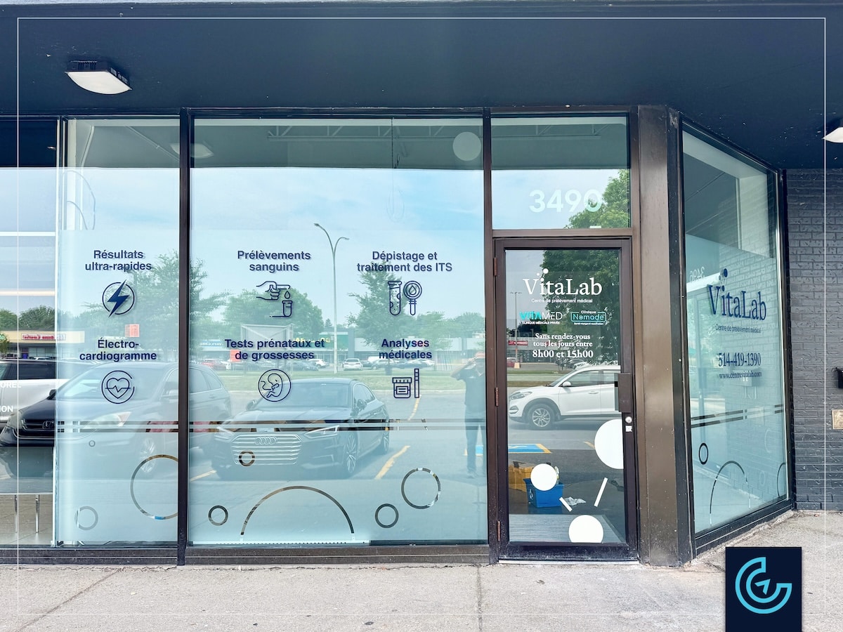 Storefront window graphics composed of frosted vinyl for privacy and die-cut color decals designed and installed for the new branch of medical laboratory Vitalab in Dollard-des-Ormeaux.