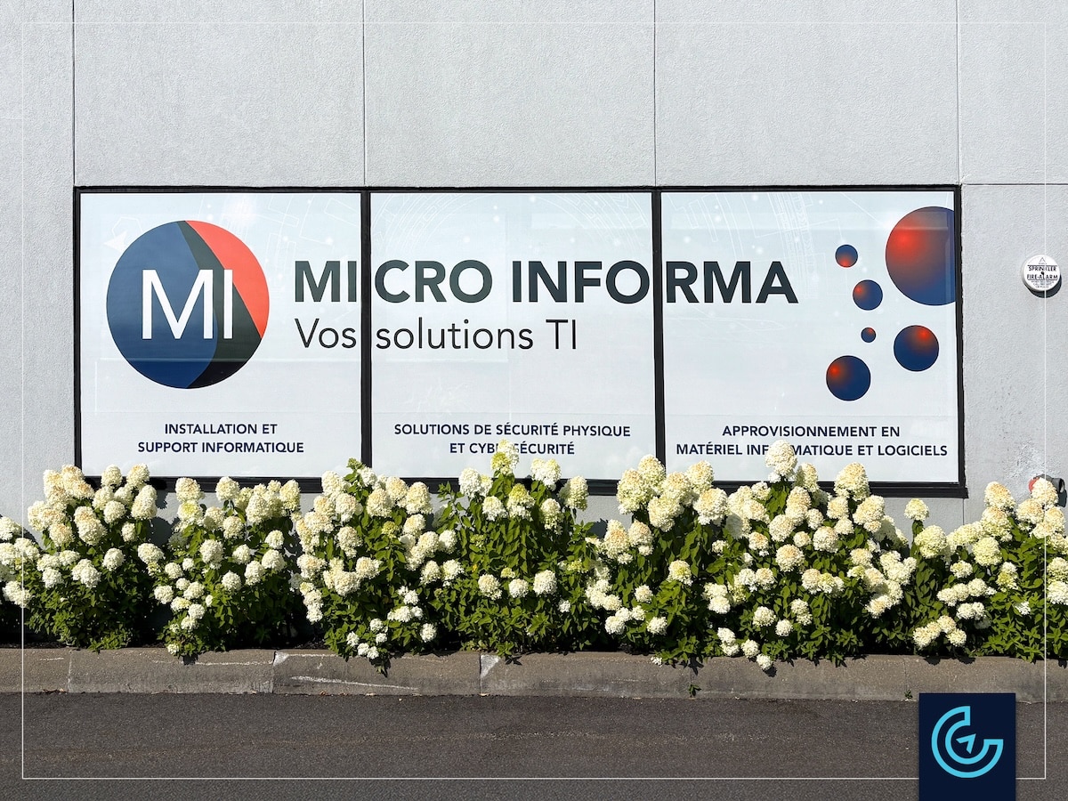 Storefront window graphics in perforated vinyl designed, printed and installed for the IT company Micro-Informa in Saint-Laurent.