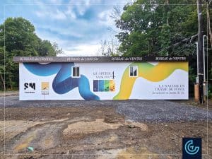 Habillage de la remorque en bois avec des bannières en vinyle mat pour le « Bureau des ventes » du nouveau projet résidentiel Quartier 4 Saisons de l'entreprise de construction Groupe Houde.
