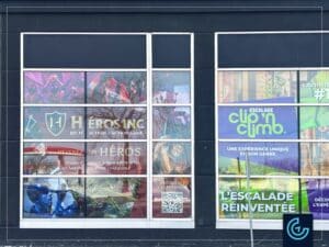 Graphiques de vitrine temporaires conçus, imprimés et installés pour annoncer l'ouverture prochaine d'un jeu d'action en équipe Héros pour le centre d'escalade Clip 'n Climb au Mall Champlain.